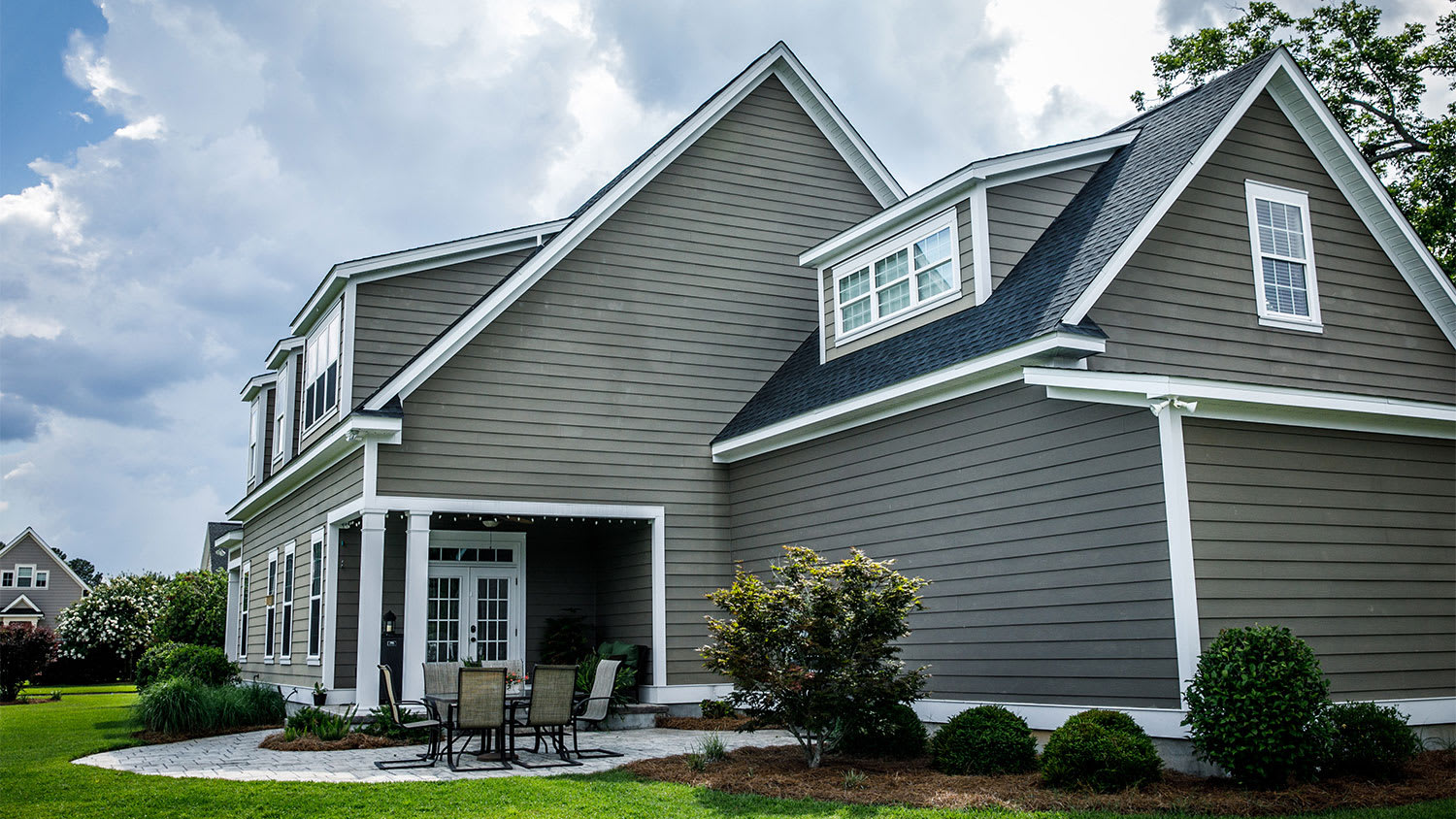 backyard view of suburban home patio and siding