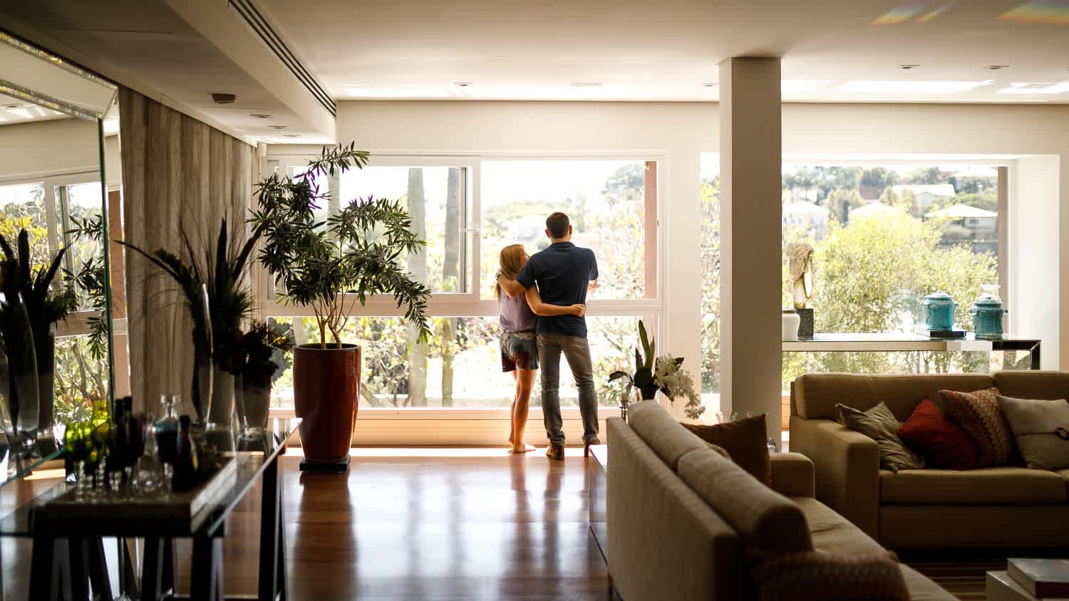 A couple enjoying the view from their house’s windows