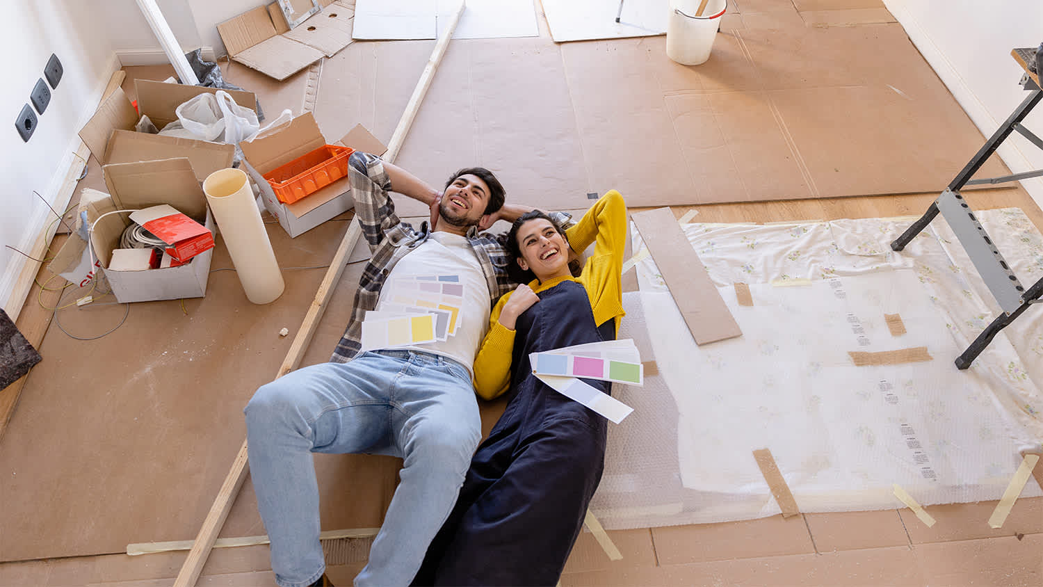 couple laying on the floor doing home renovations