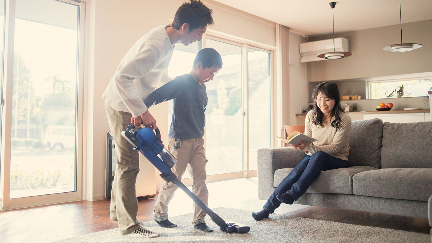 Father teaching son how to use the vacuum cleaner