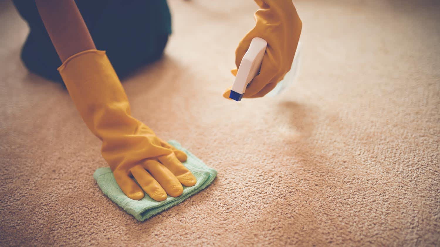 A woman removing stain from the carpet