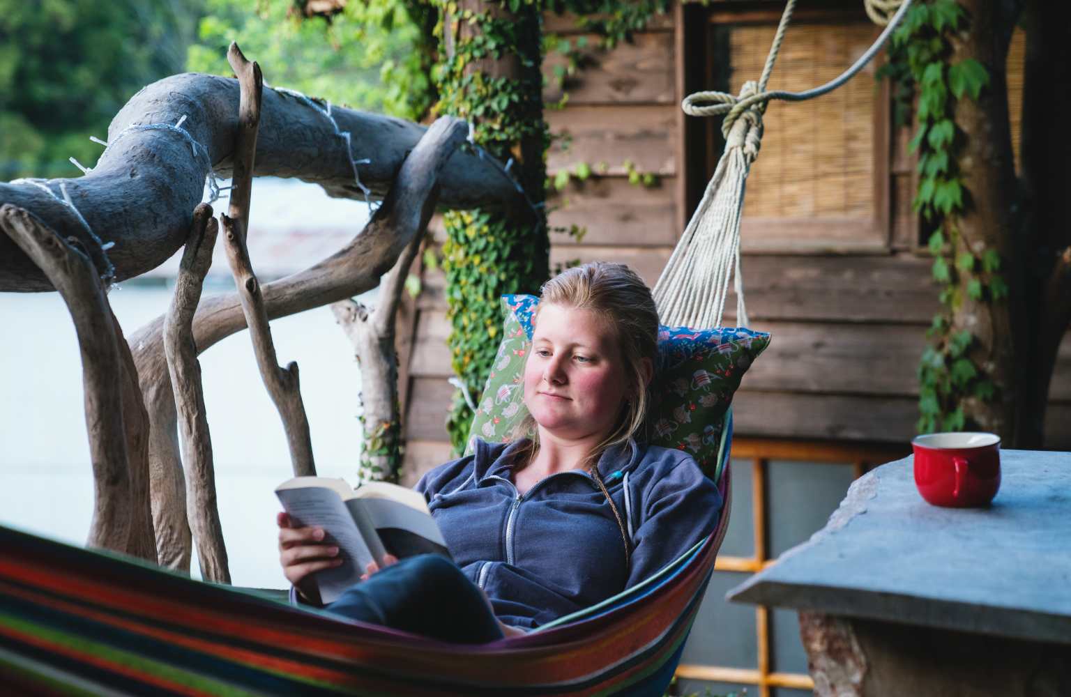 woman reading book in hammock