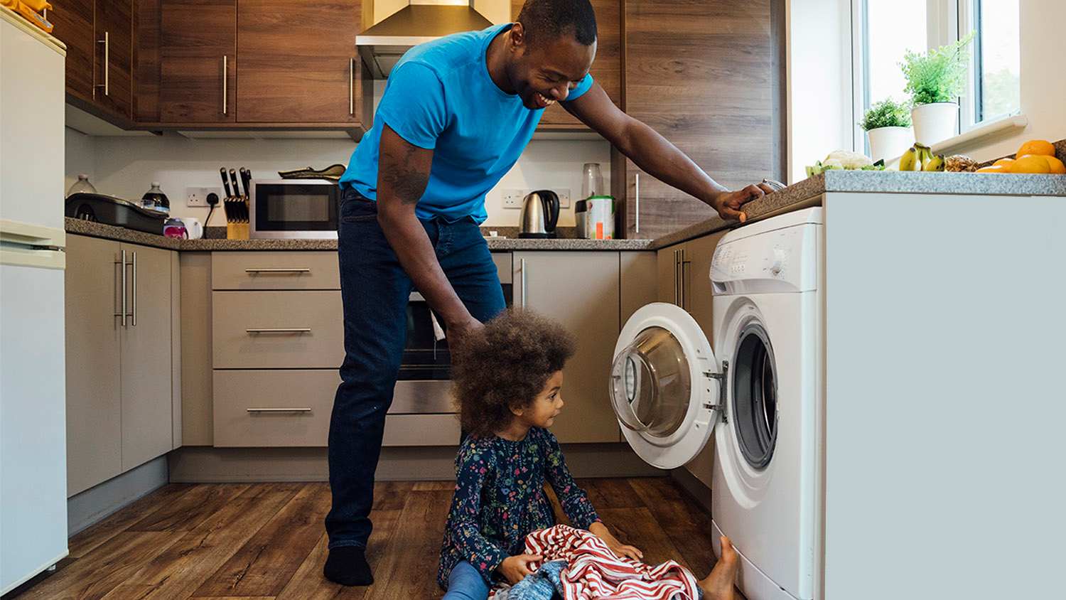 father washing clothes with daughter