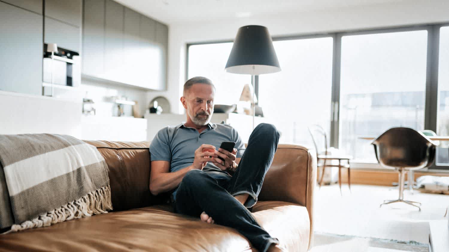 A man looking at mobile phone on sofa