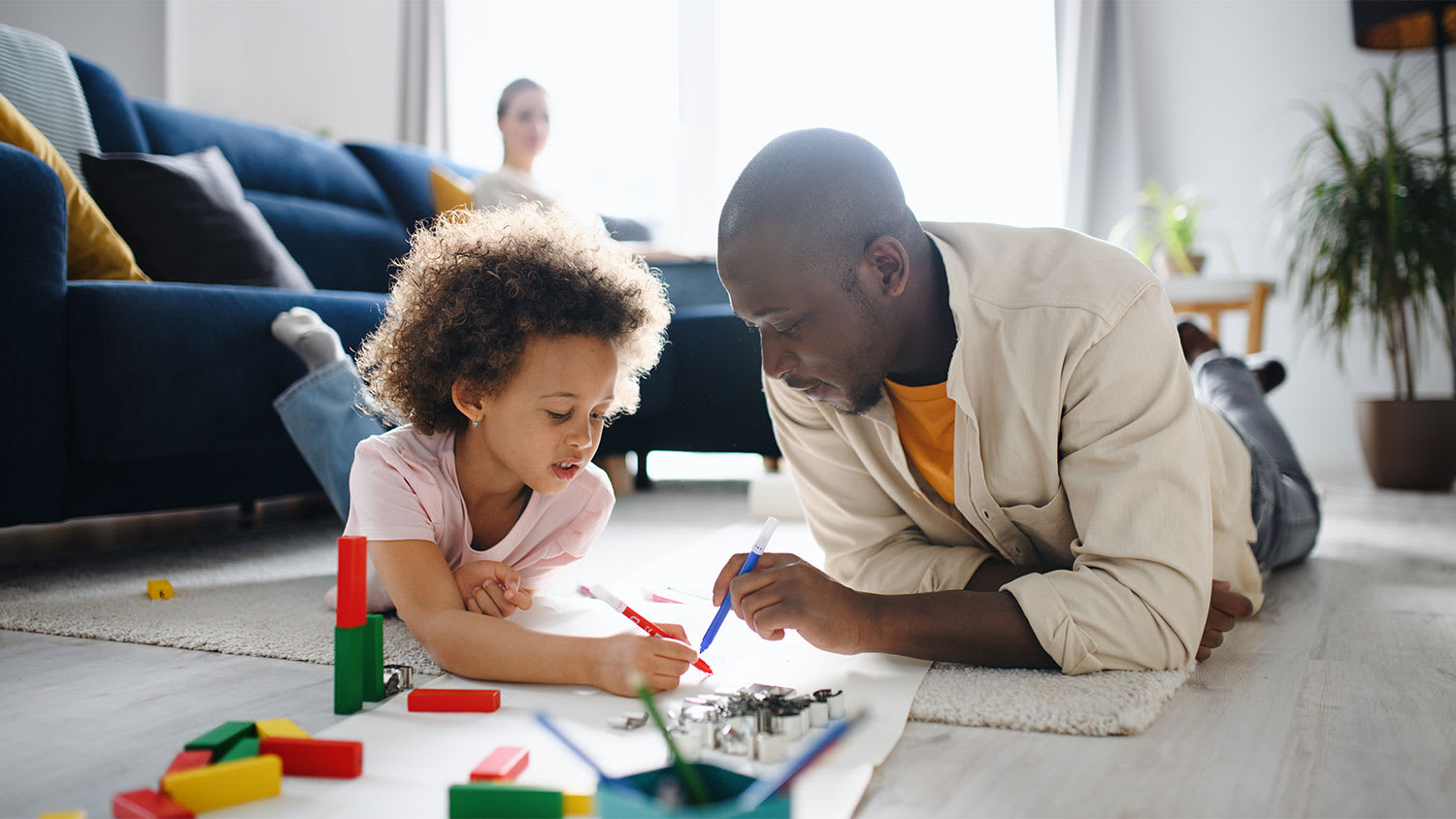 A father and child draw at home