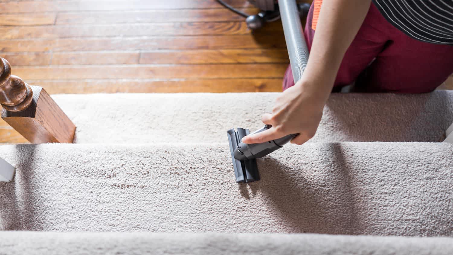 Vacuuming carpeted stairs with an attachment