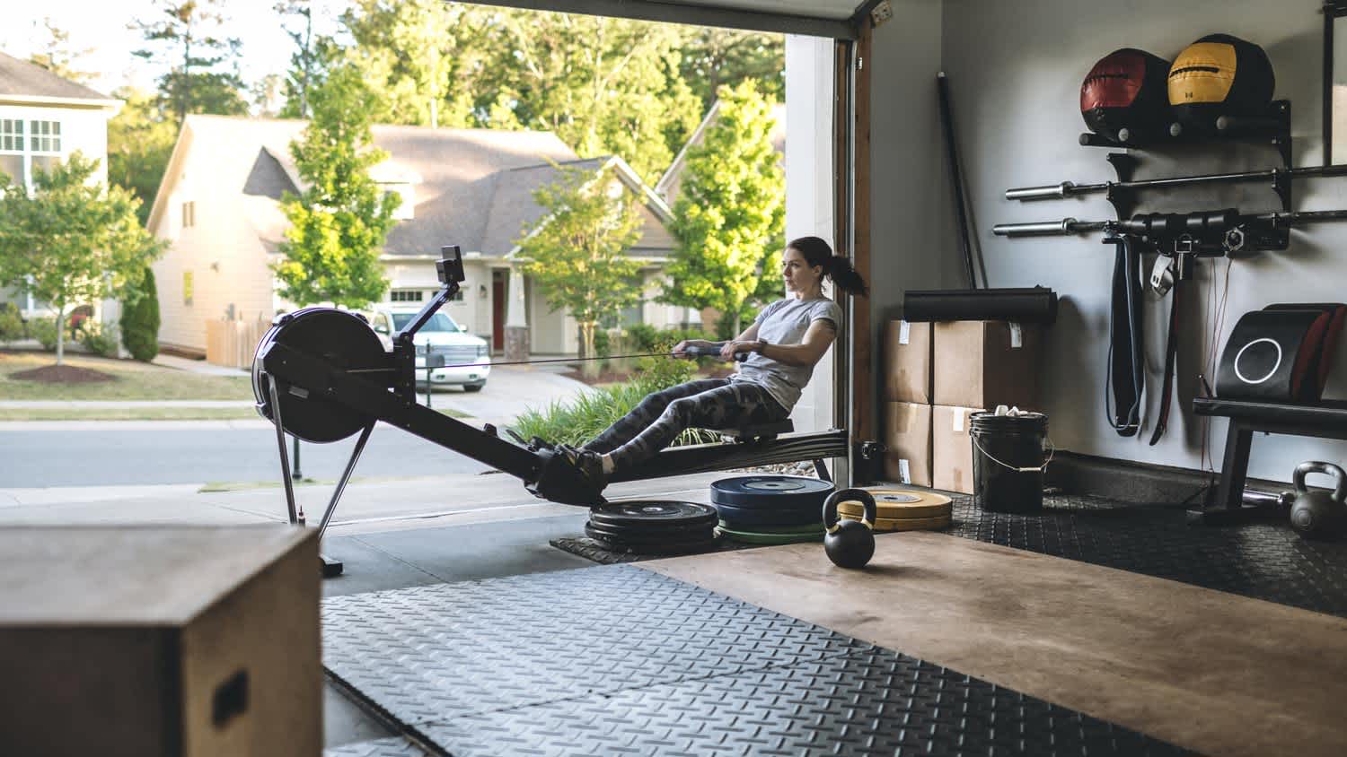 A woman exercising on a rowing machine in her home gym