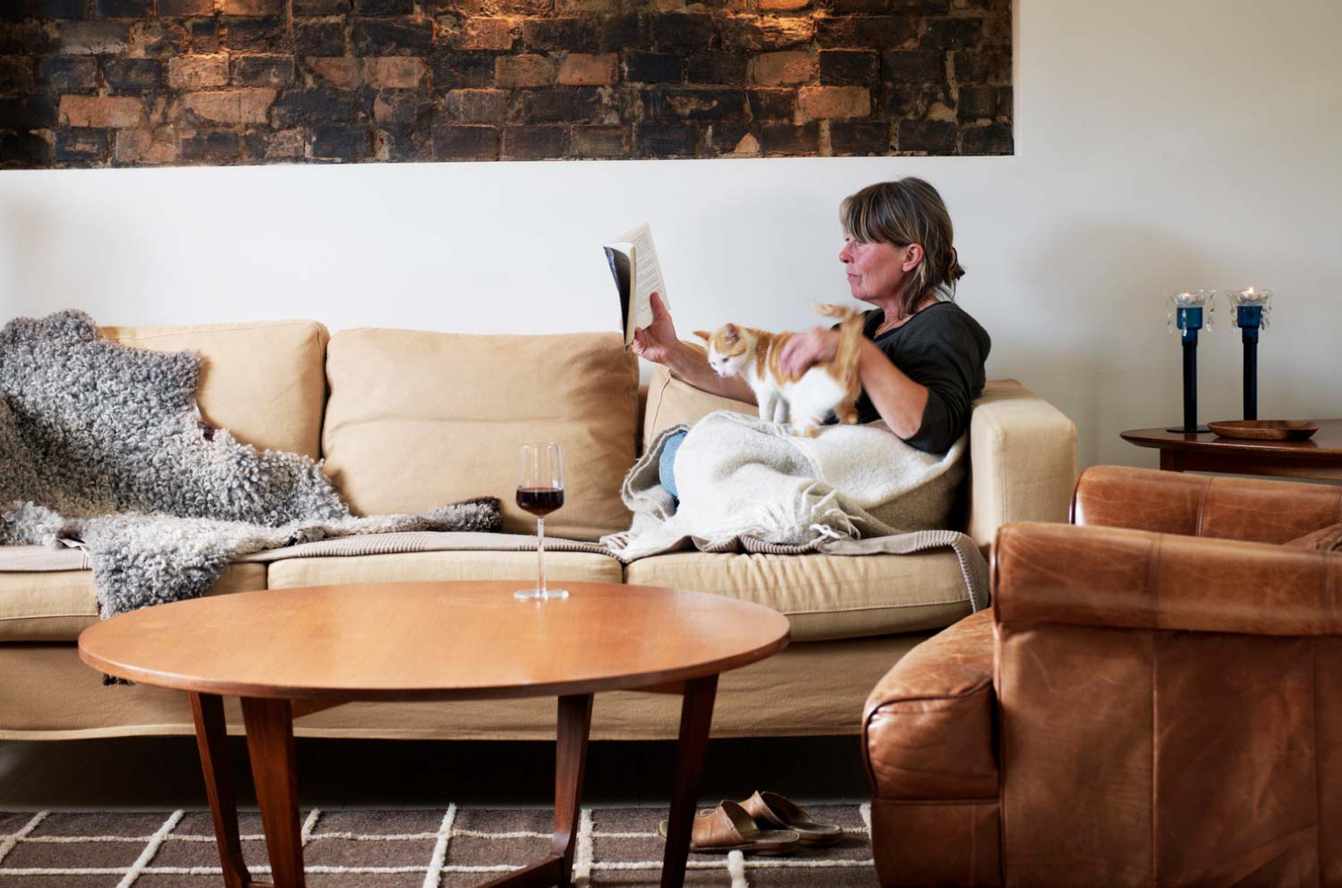 A woman reading with her cat in the living room