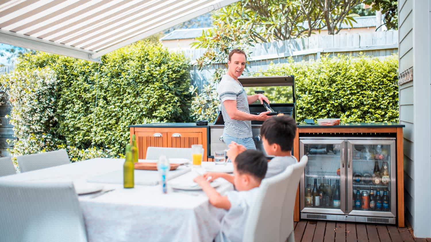 A father grilling in an outdoor kitchen
