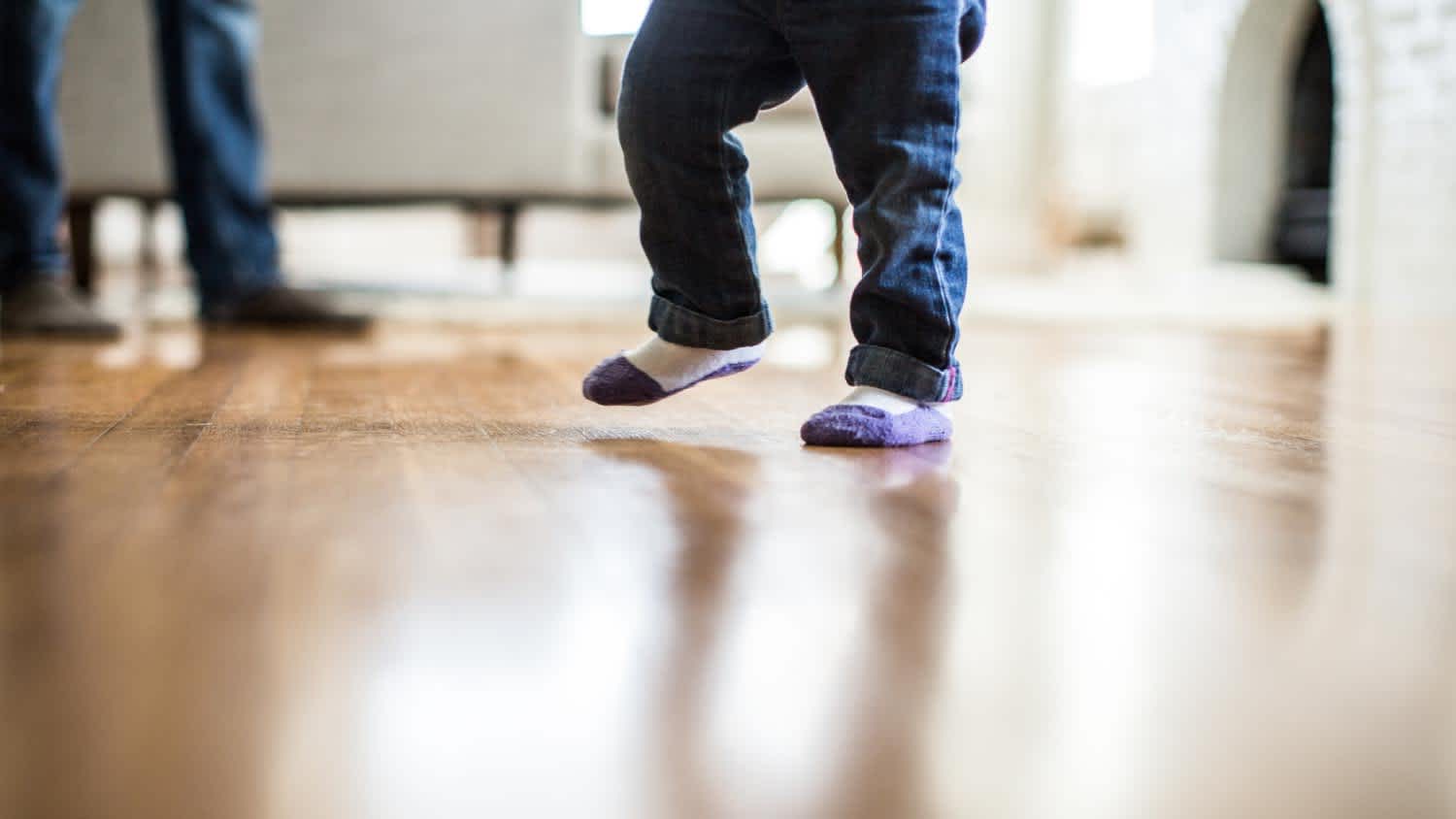toddler walking on hardwood floor in home