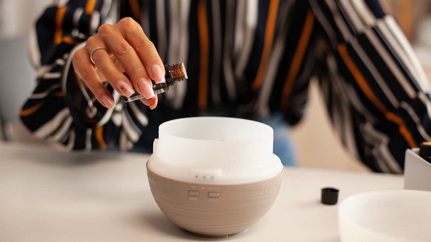 woman pouring oil into diffuser