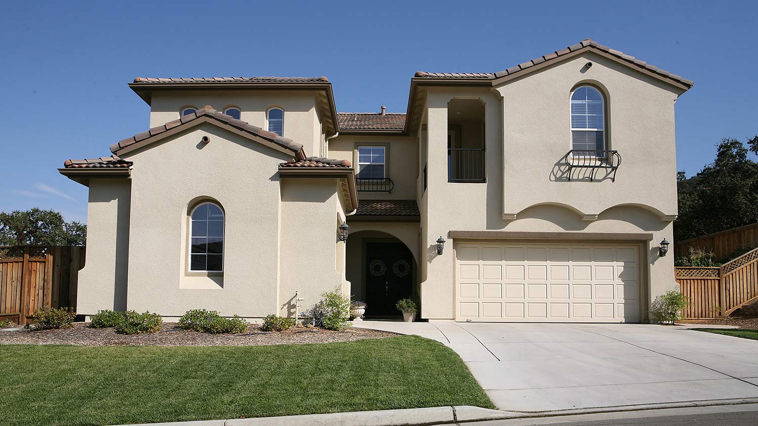 Two story stucco home with brown tile roof