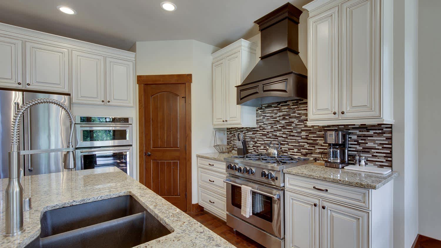 Modern white kitchen with stainless steel appliances