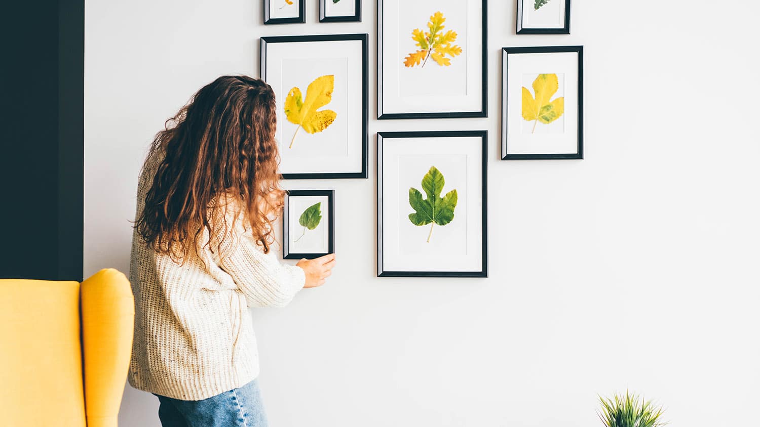 woman hanging up picture frames