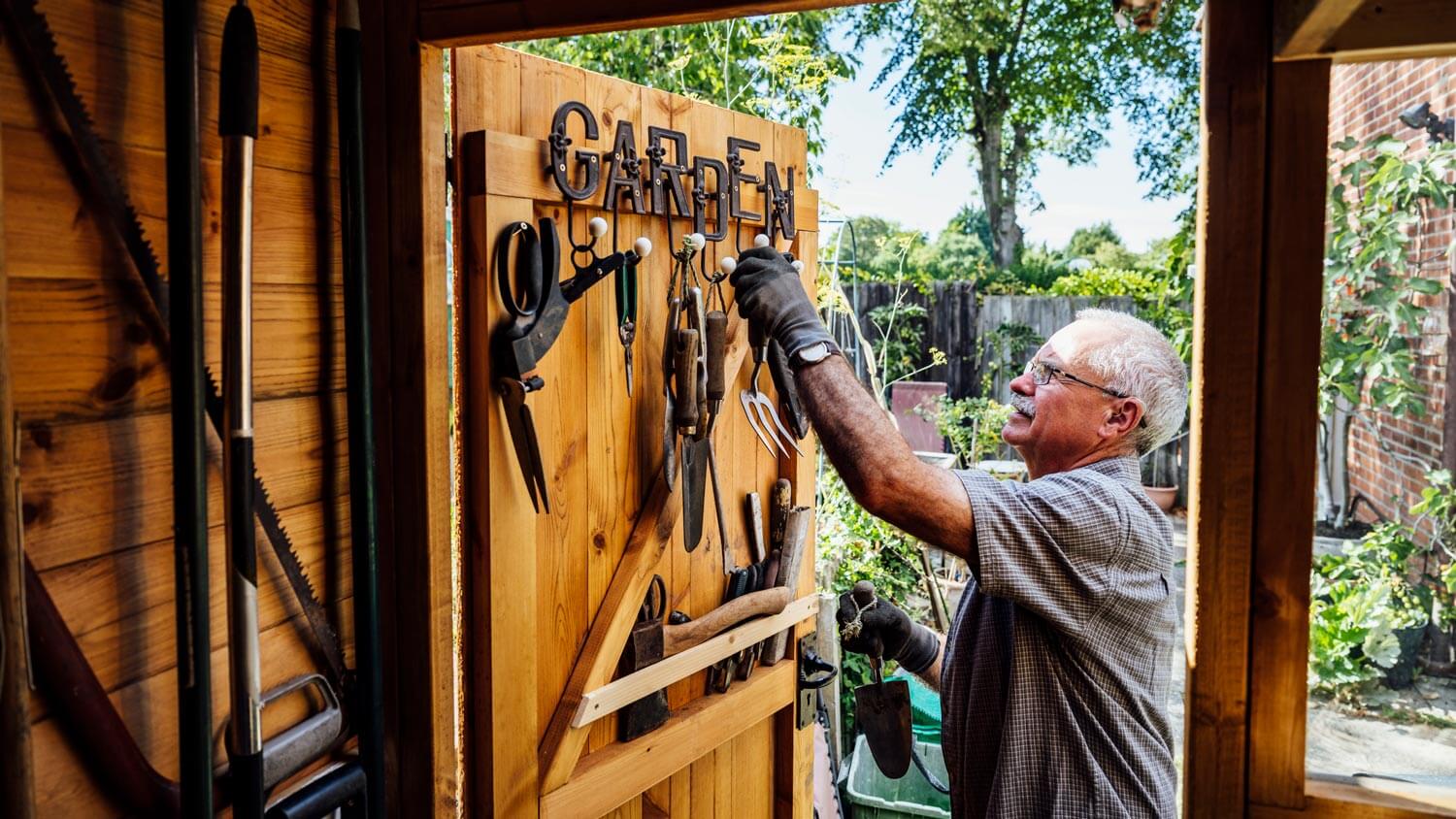 A senior man hanging vertically the garden tools