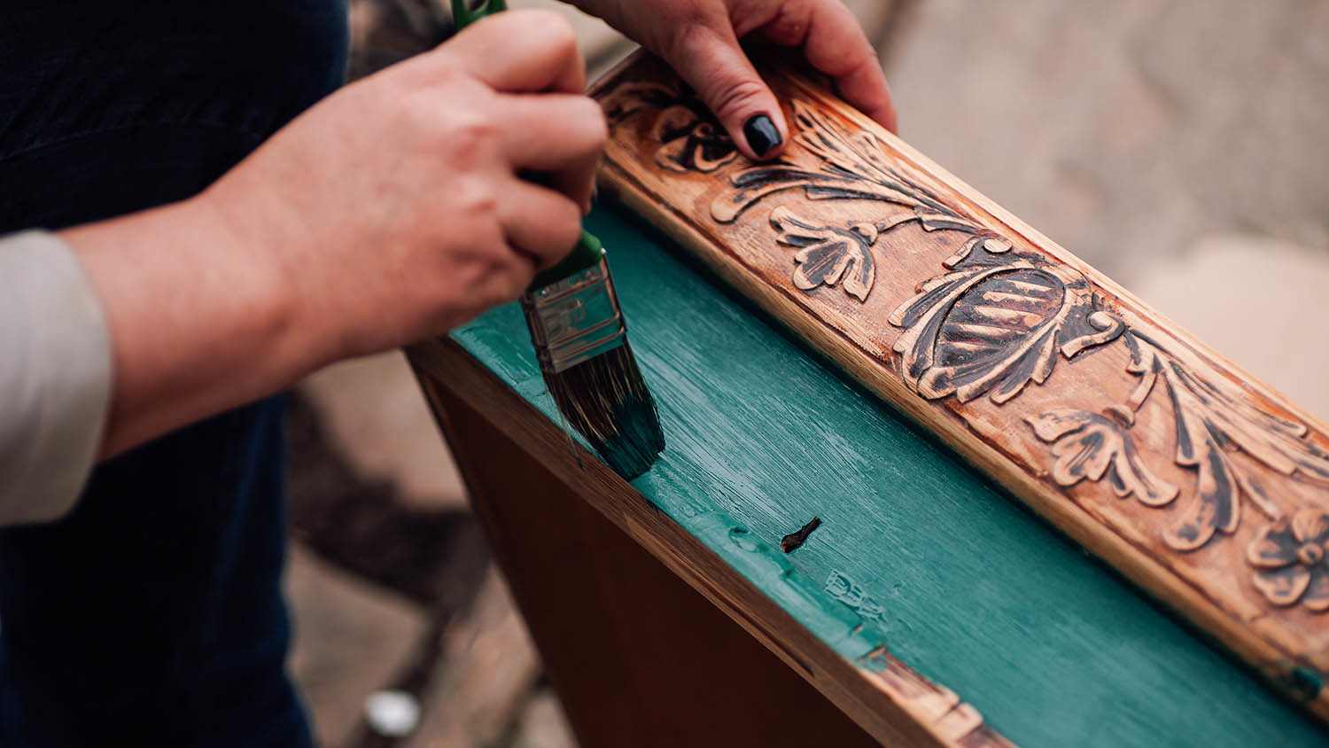 person painting antique wooden furniture