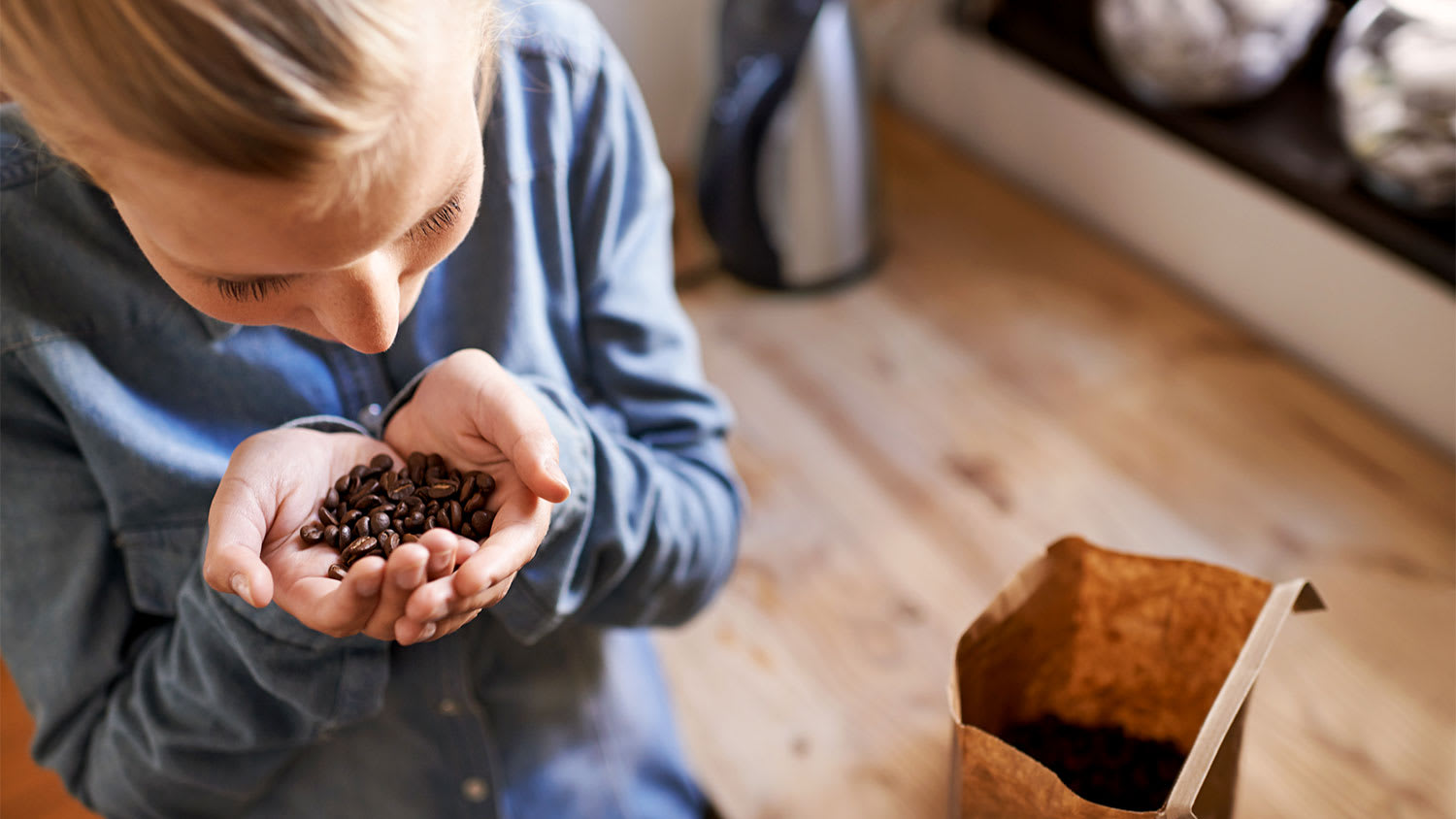 A woman smells coffee beans