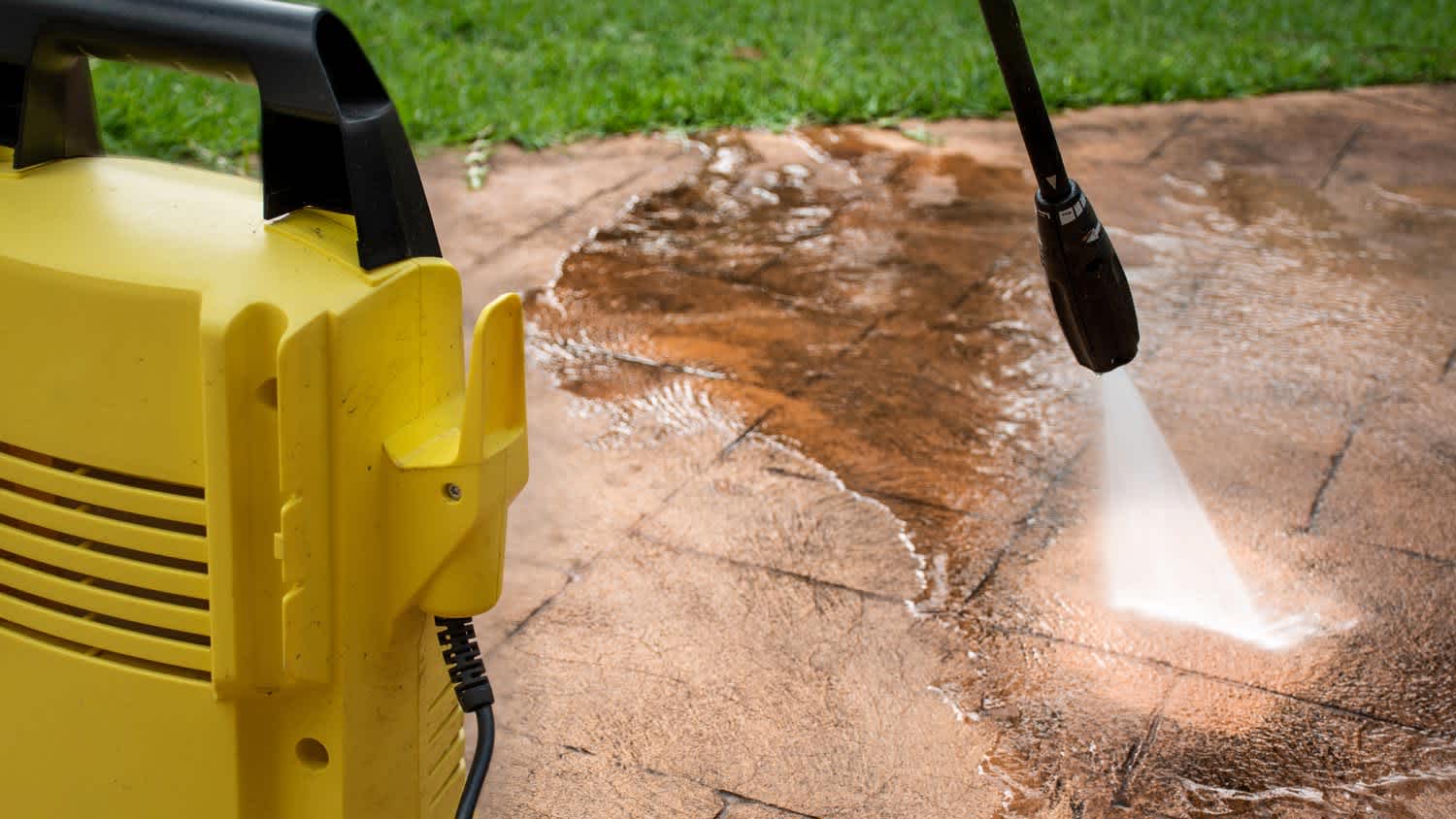 Pro power washing an outside stone patio