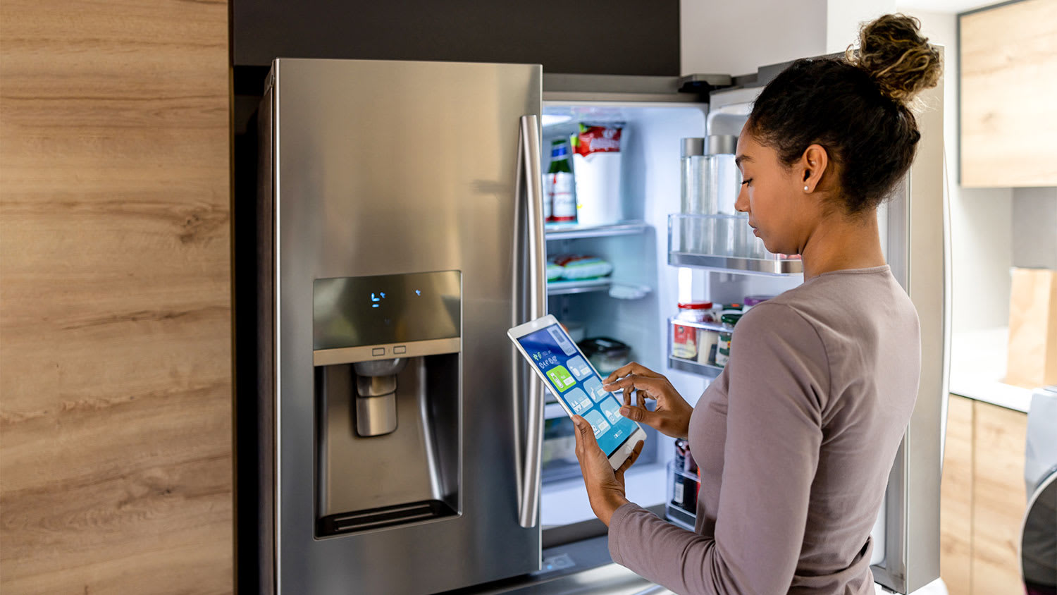 Woman using smart refrigerator