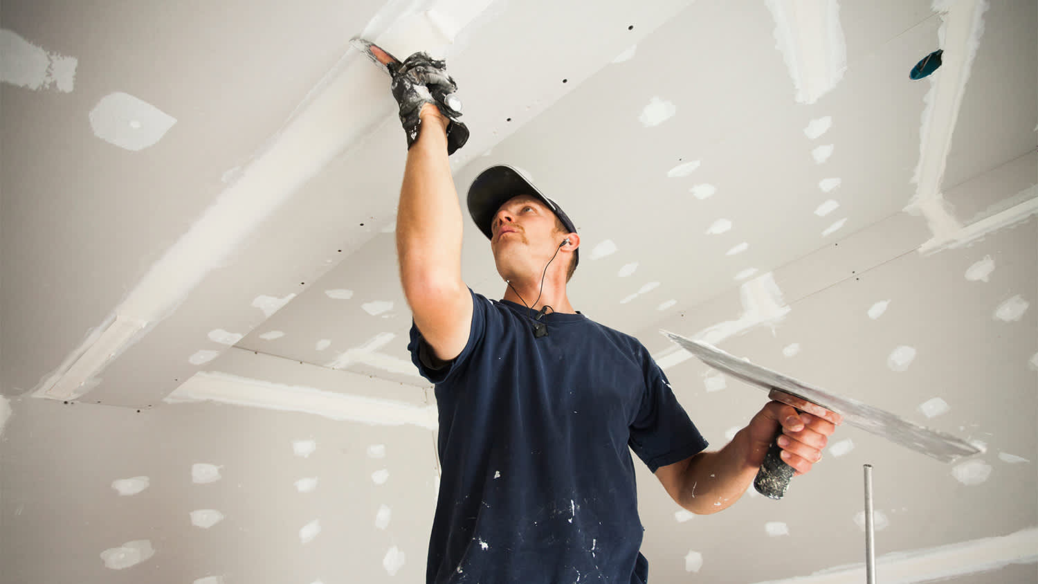 Man patching drywall ceiling