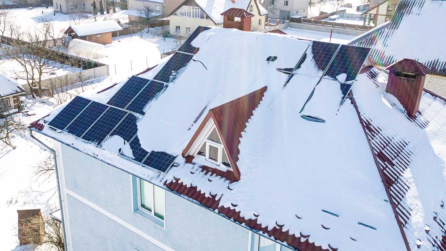 Snow covers solar panels on a house
