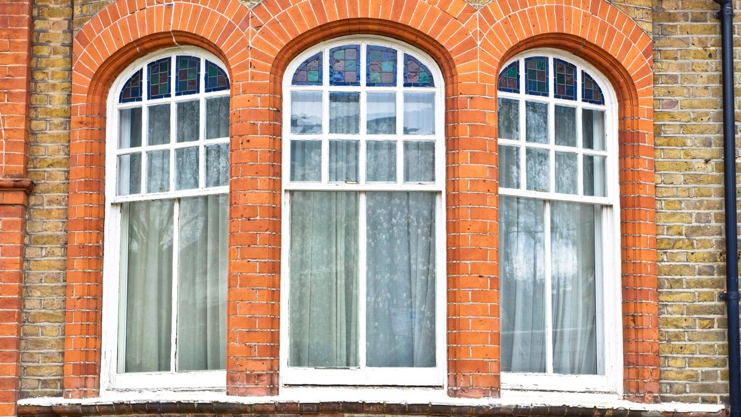 The exterior of a bay window with closed drapes