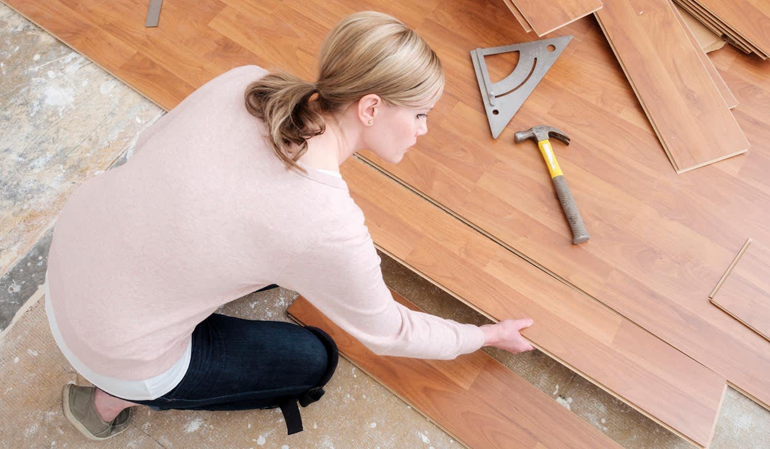 Woman installing laminate flooring