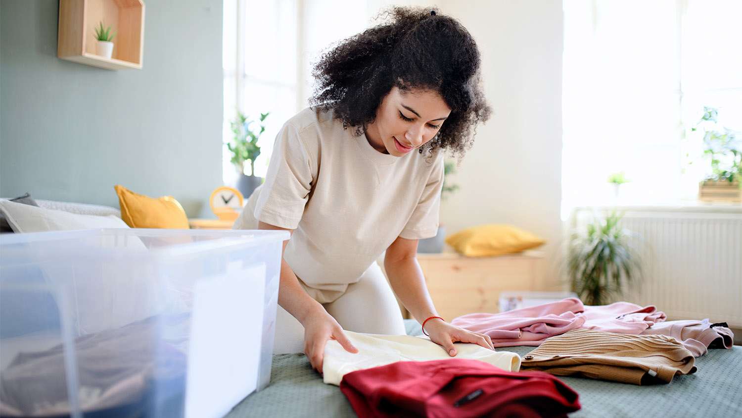 woman storing clothes in bin