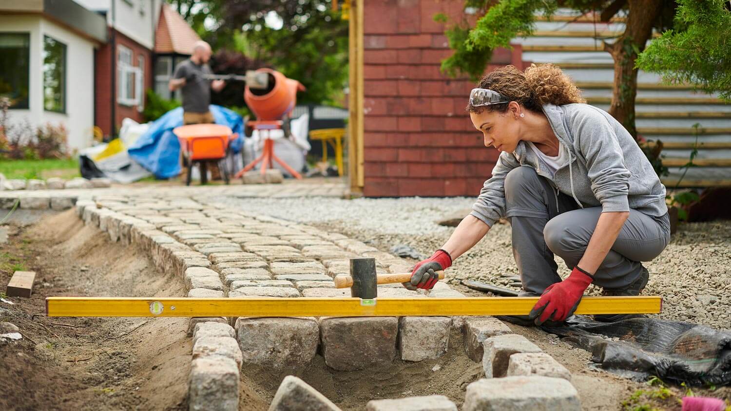 A woman installing pavers
