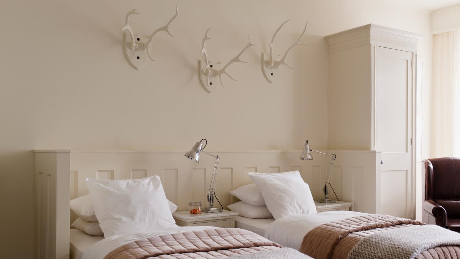White twin bedroom with mounted antlers