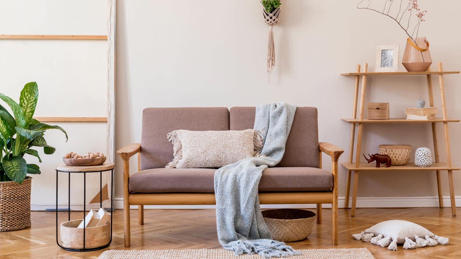 A japandi style living space with a wooden sofa and a macrame