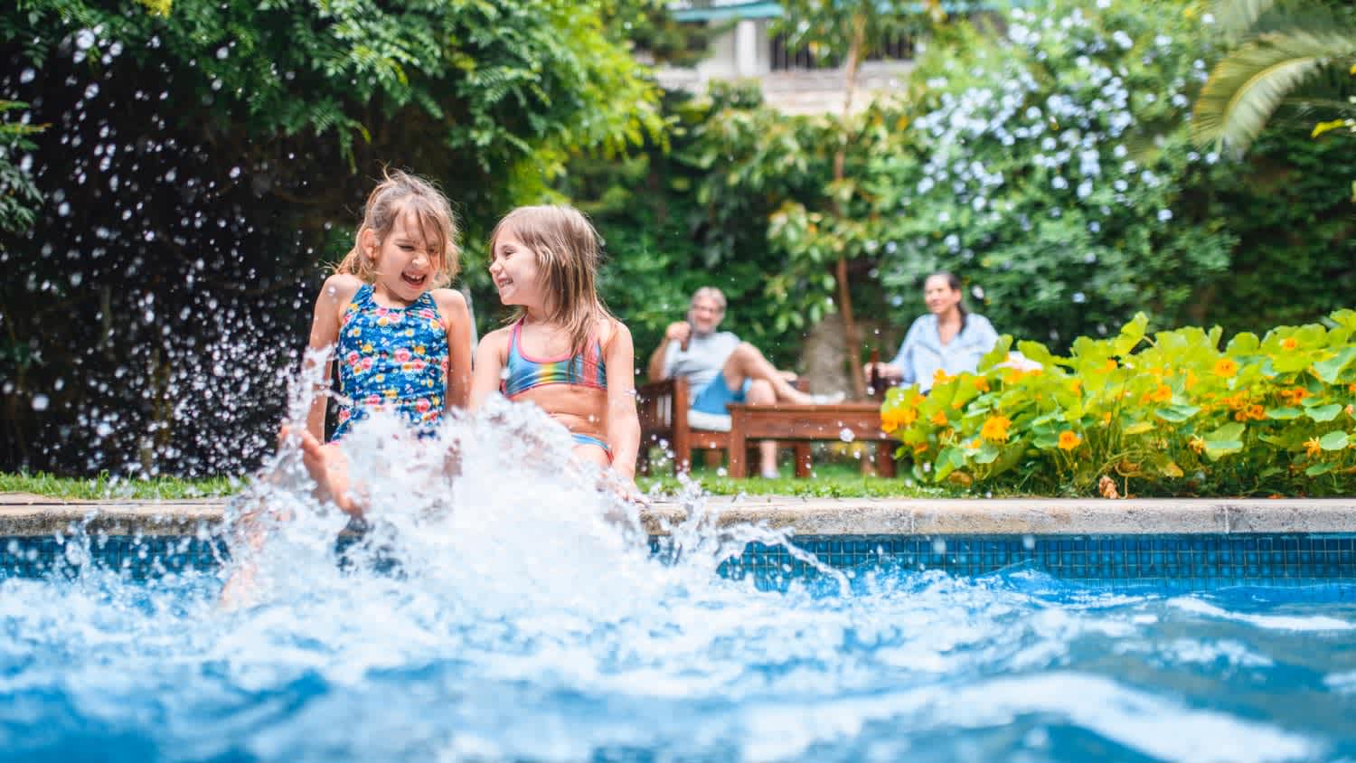 Girls sitting on side of pool