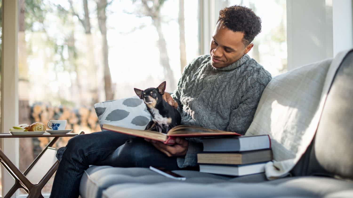 A man sitting on a sofa with a dog