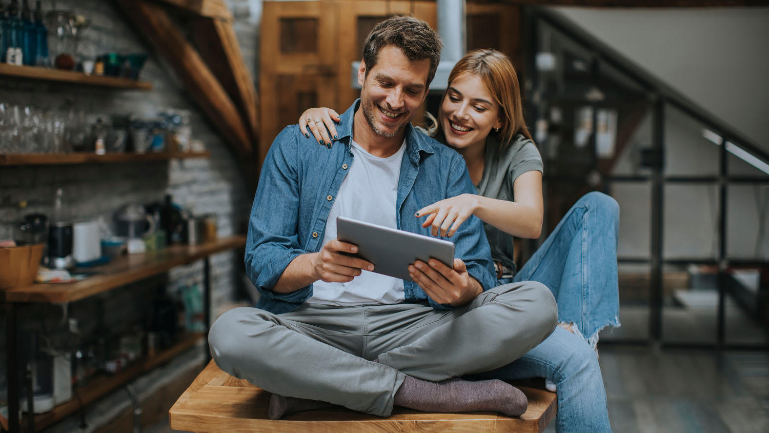 A young couple using a digital tablet in kitchen at home