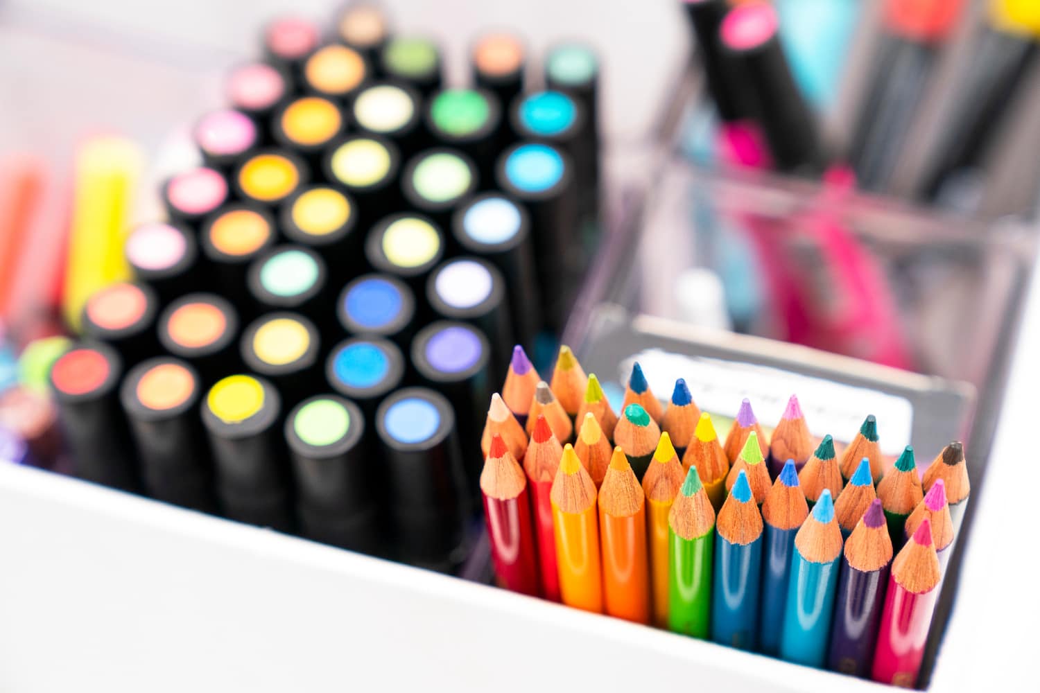 Markers and colored pencils lined up in containers