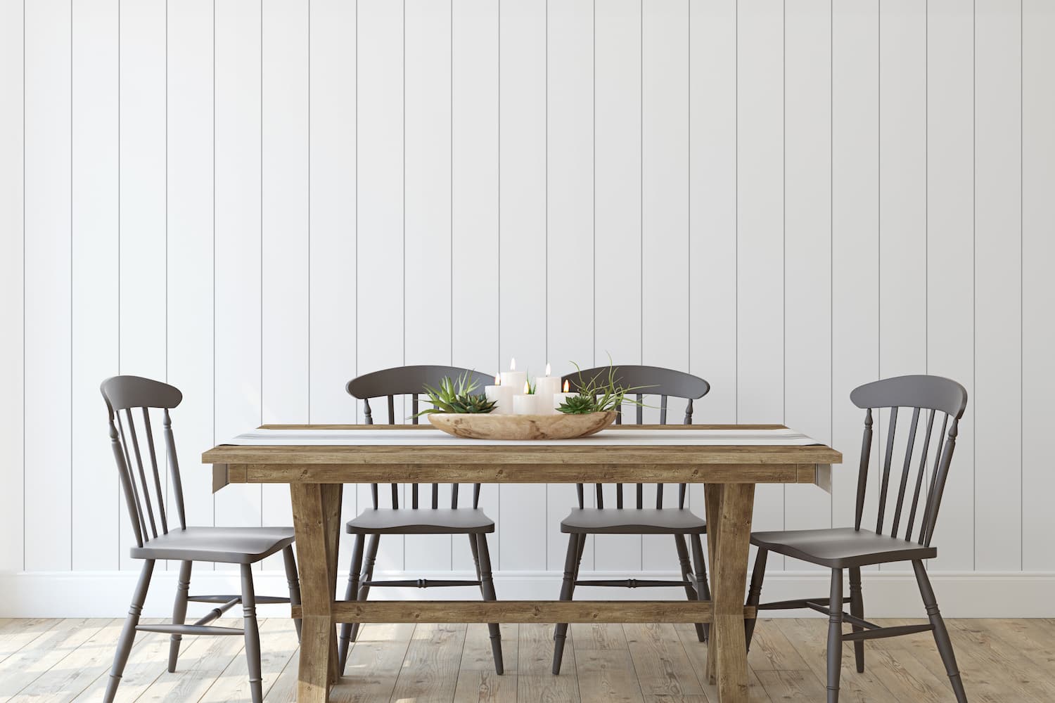 Farmhouse dining table and chairs in front of white vertical shiplap accent wall