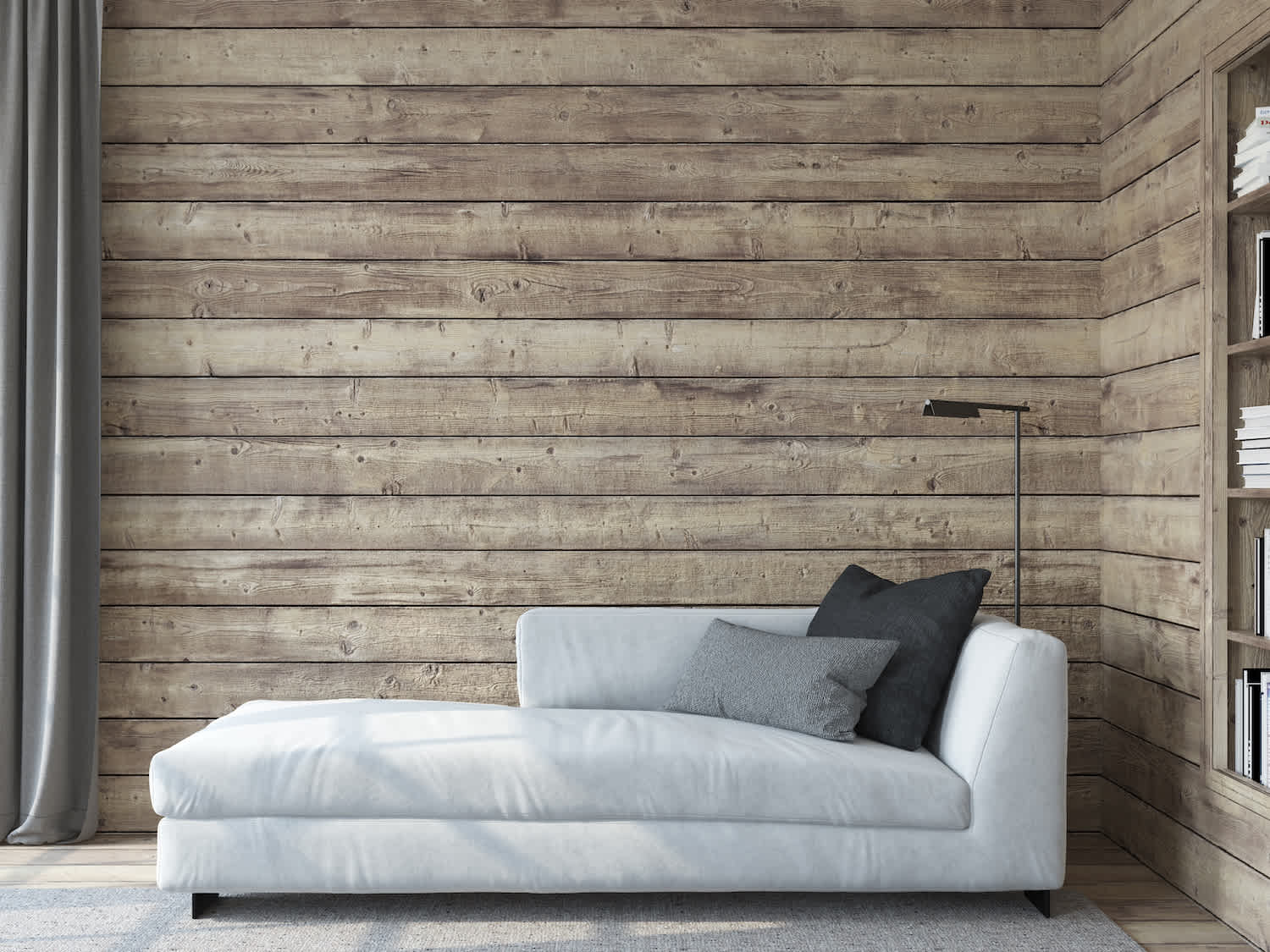 Living room with a gray couch in front of rustic wood shiplap walls and built-in bookshelves