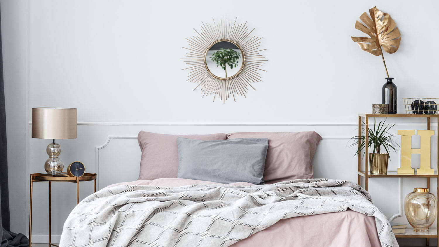 A bedroom with a sunburst mirror