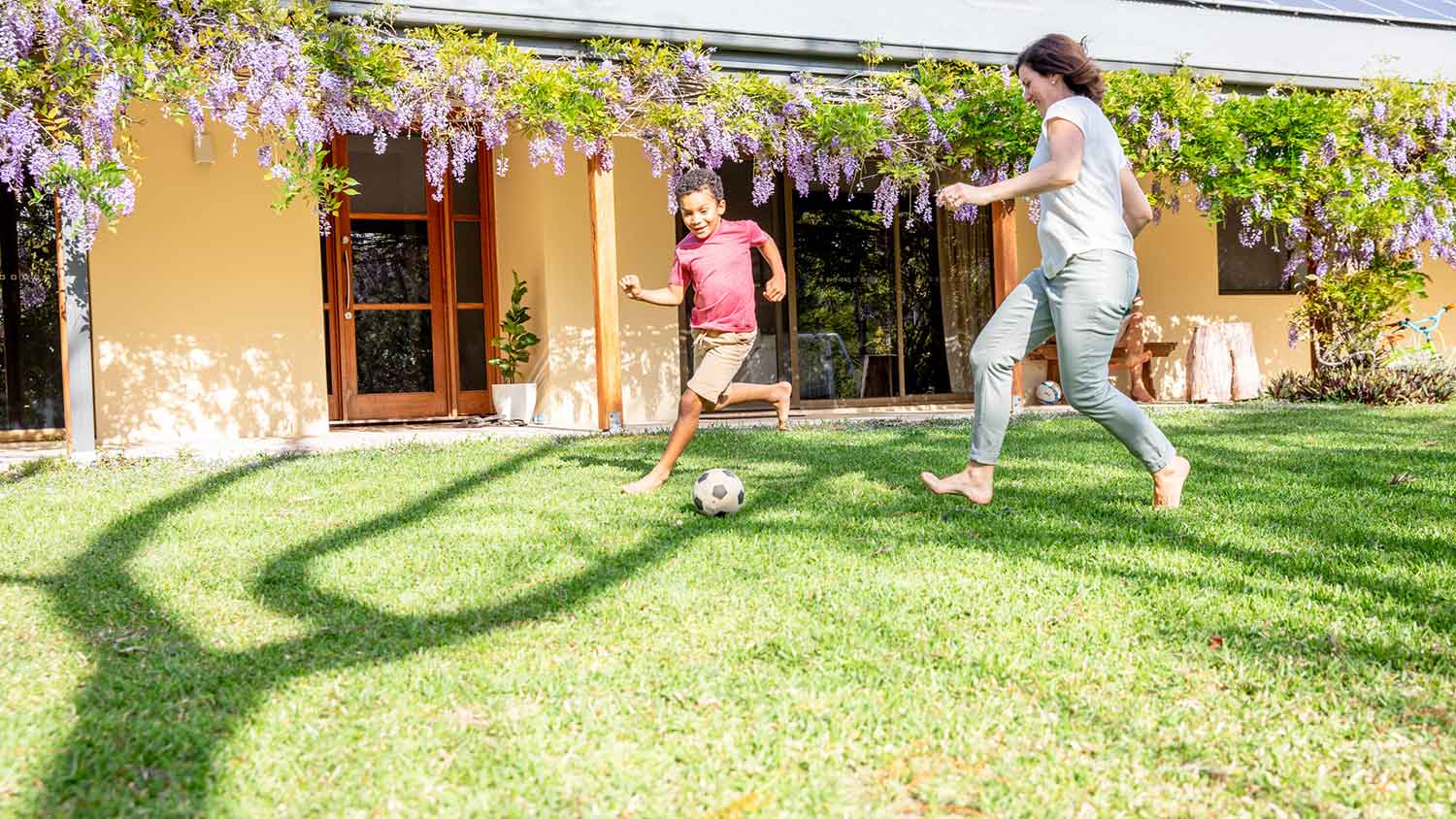 Mother and son playing soccer in the backyard