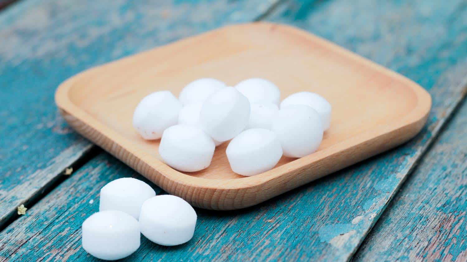 Moth balls on the wooden plate