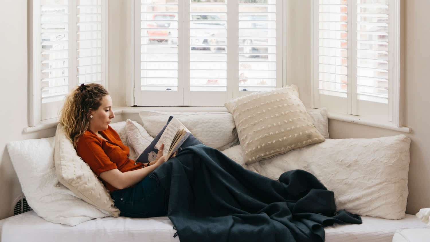 A woman reading a book on sofa