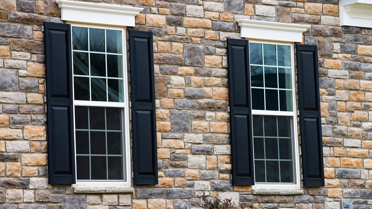 black paneled shutters on brick house