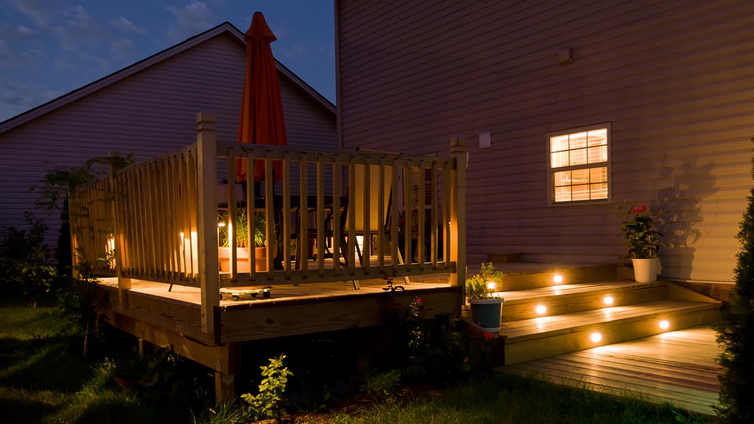 Pathway lights on the wooden steps leading to a house’s patio