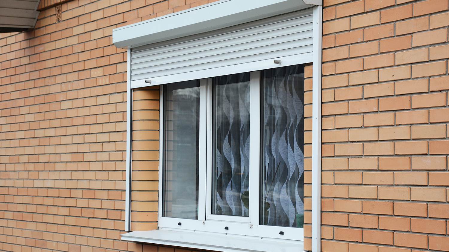 metal rolling shutters on brick house