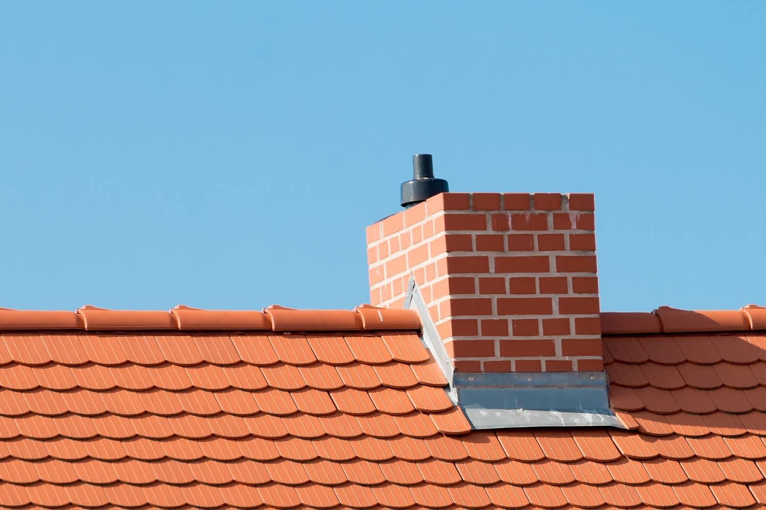 A roof with red tiles and chimney
