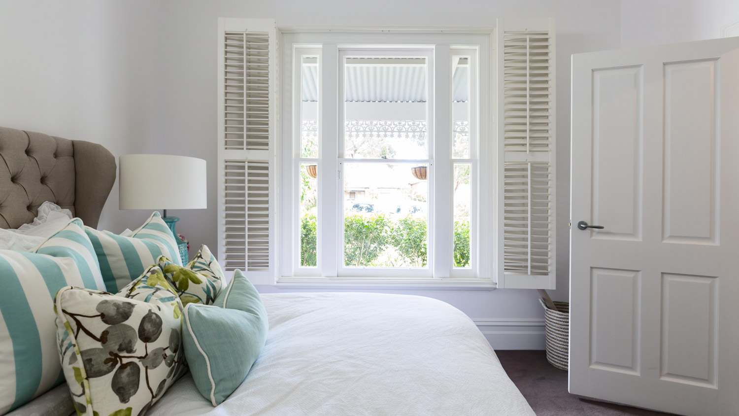 White wooden shutters in a bedroom