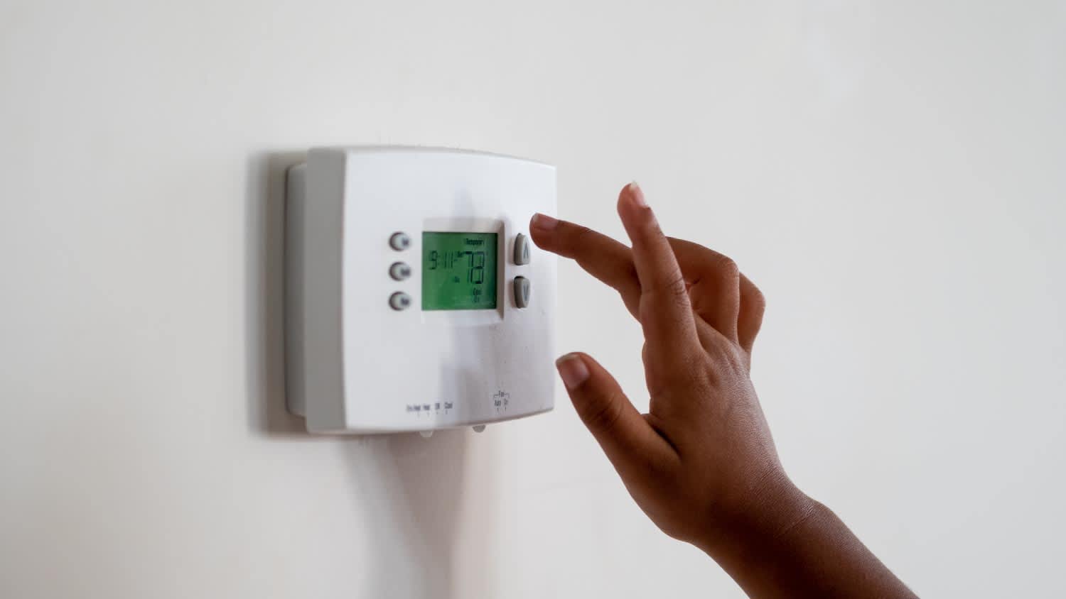 Woman touching a Thermostat