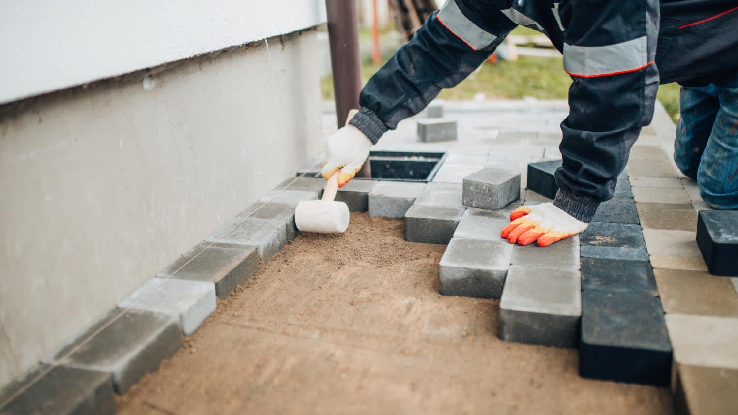 Worker installing footpaths in the backyard