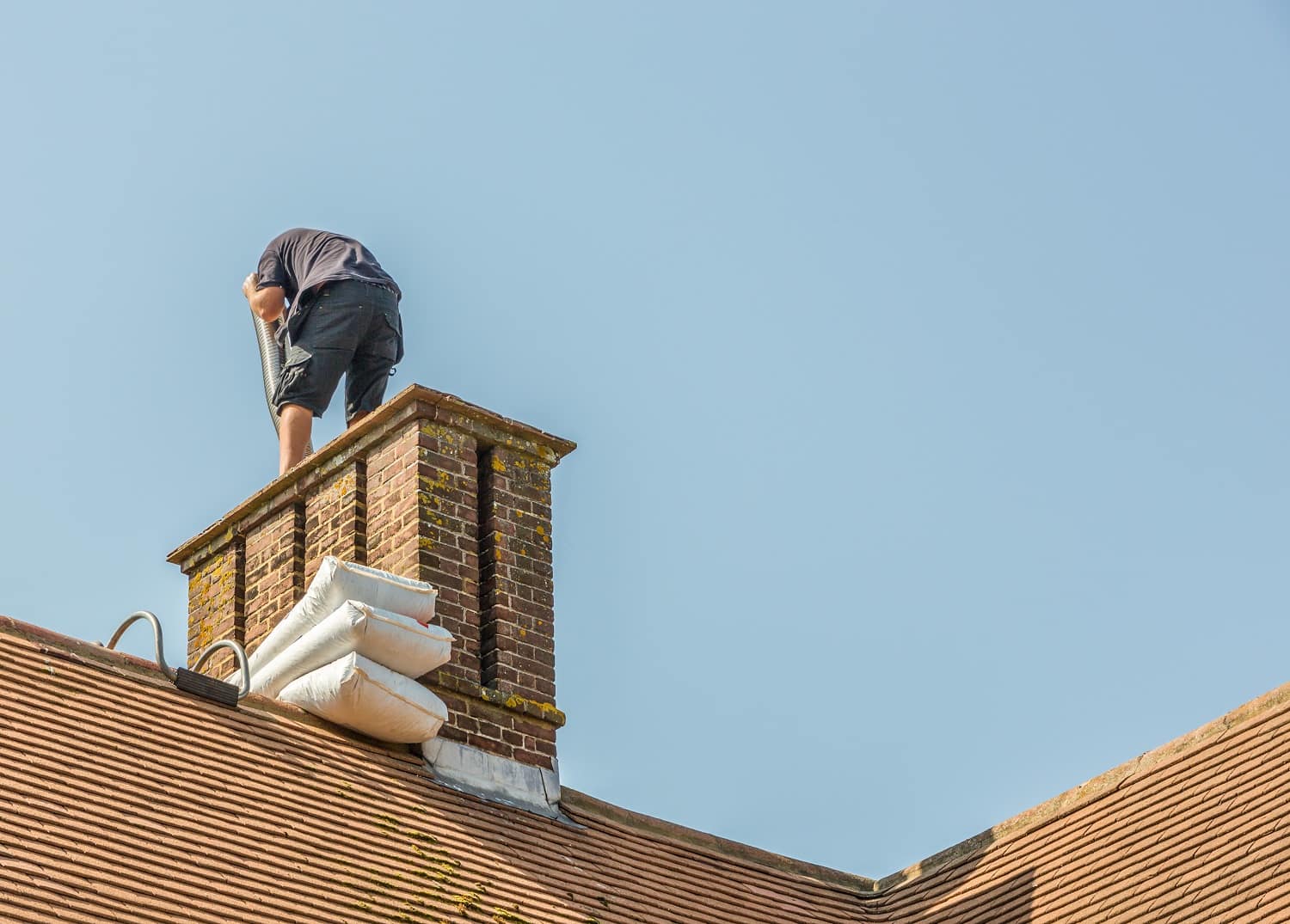A worker installing a chimney liner on a house