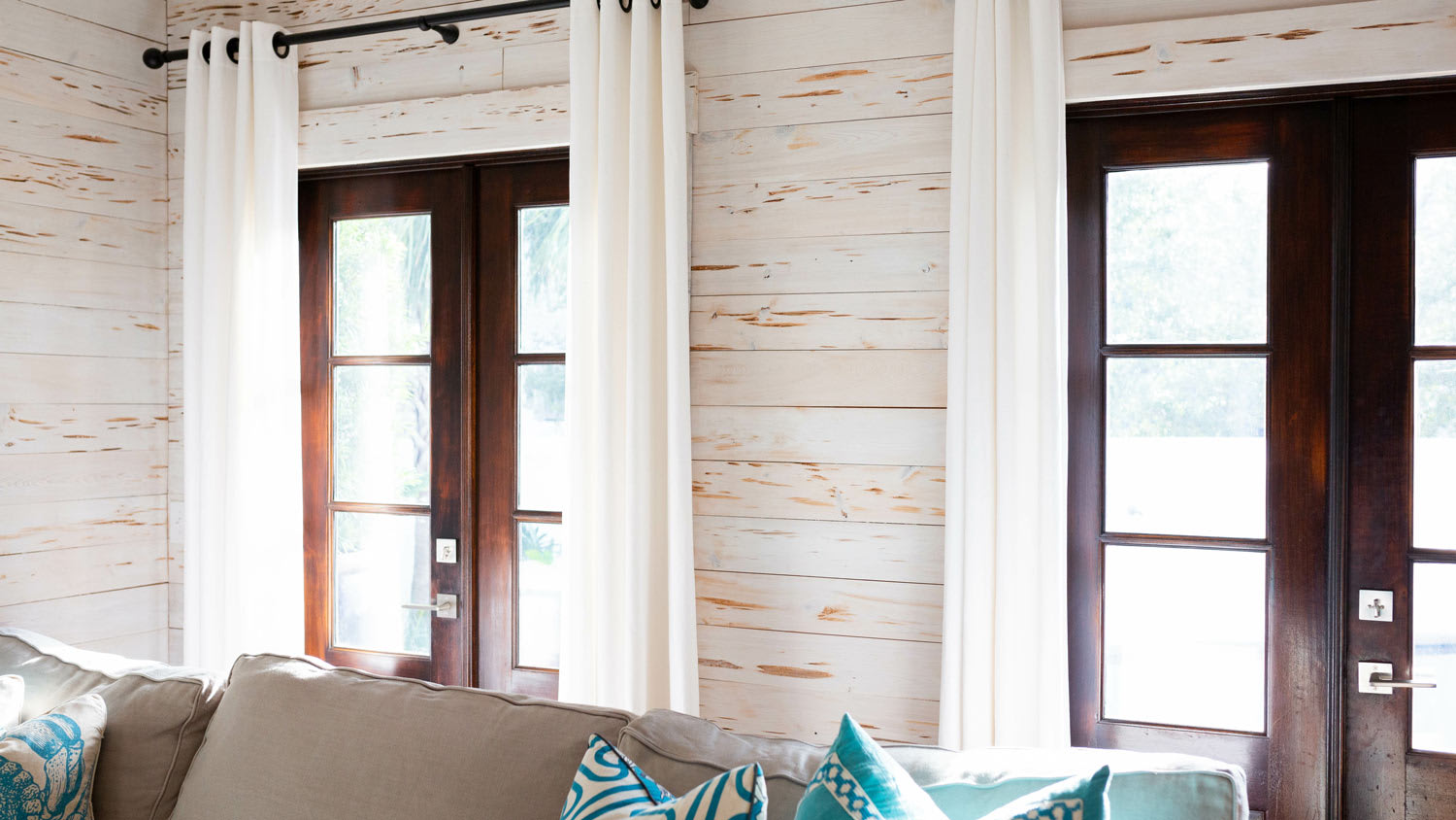A living room with a sofa and shiplap wall